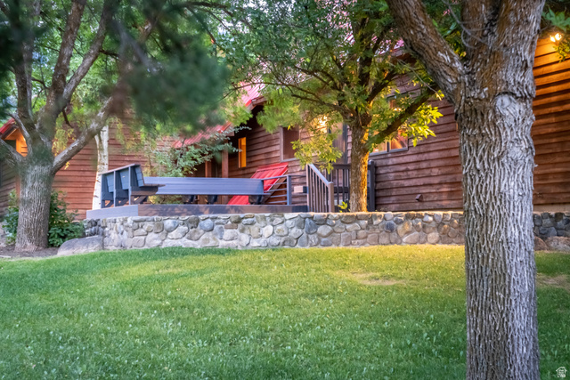 435 Canyon Road Millville, UT 84326 - Photo 62 of 113 Wood-clad exterior with a red roofline and a stone retaining wall