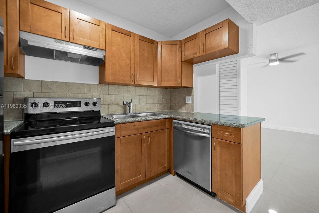6953 Southwest 5th Street Margate, FL 33068 - Photo 12 of 45 a kitchen with stainless steel appliances granite countertop a stove and a microwave