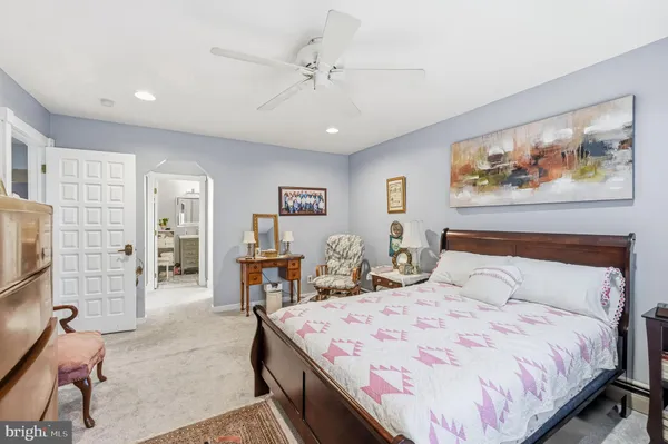 a bedroom with a large bed a rug and chair