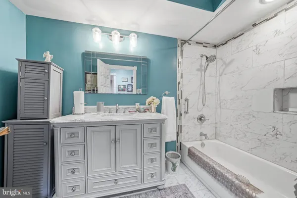 a bathroom with a tub a sink and a mirror