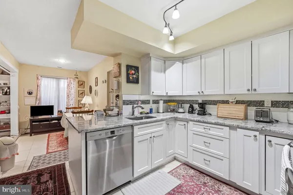 a kitchen with granite countertop a sink a stove and cabinets