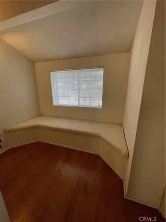 a white toilet sitting next to a wooden cabinet