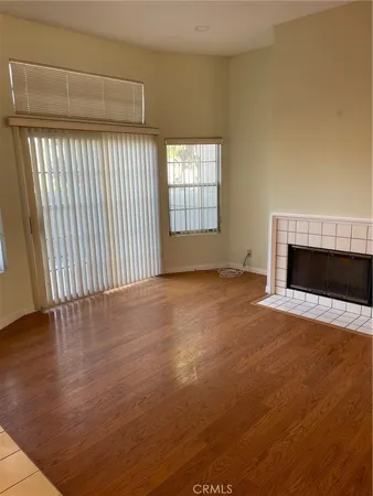 a view of empty room with wooden floor and fireplace