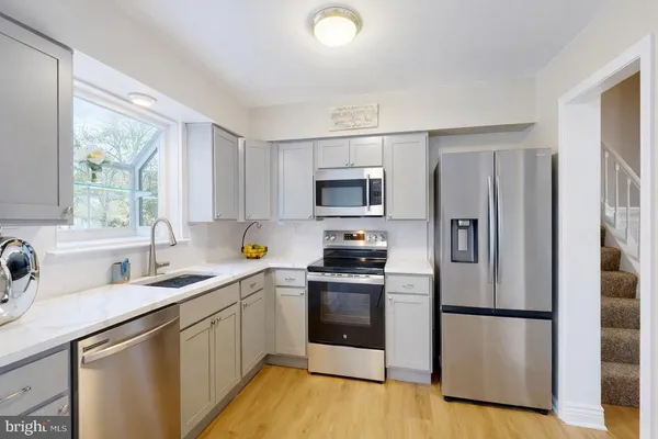 a kitchen with a refrigerator sink and wooden floor