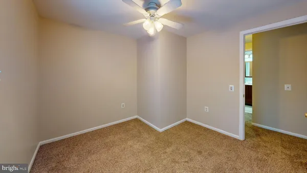 an empty room with a fan & a ceiling fan