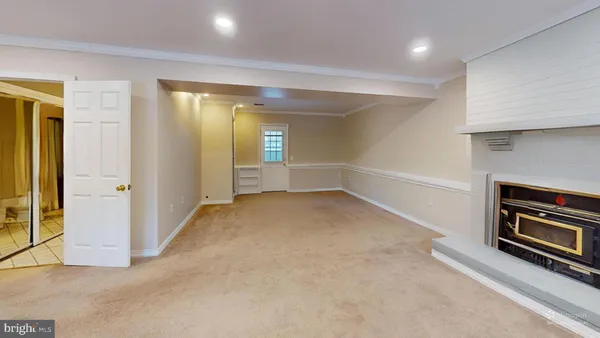 an empty room with windows and fireplace