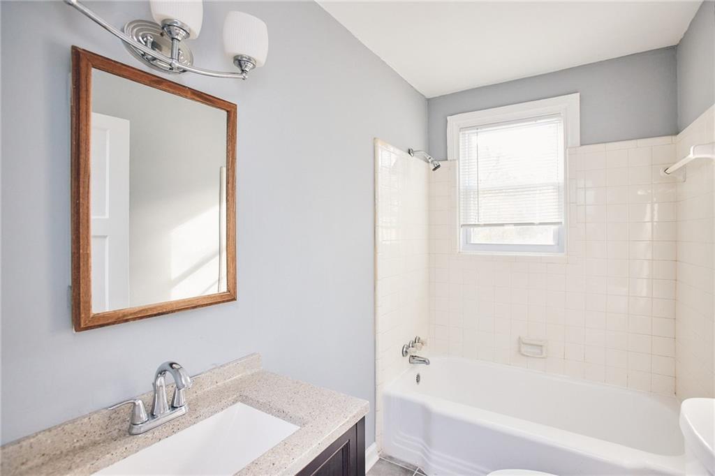 3323 Midway Road, Unit 1 Decatur, GA 30032 - Photo 4 of 10 a bathroom with a bathtub a sink and a mirror