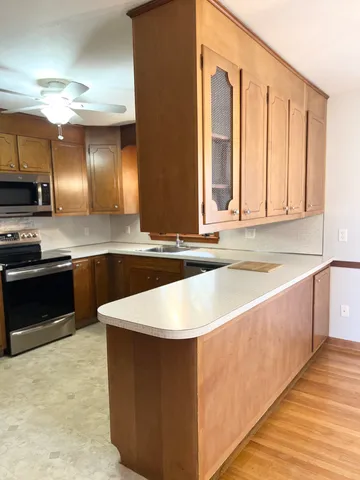 a kitchen with stainless steel appliances granite countertop a sink dishwasher stove and refrigerator with wooden floor