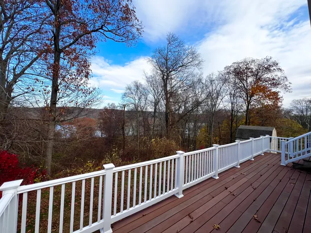 a view of deck with wooden floor and trees