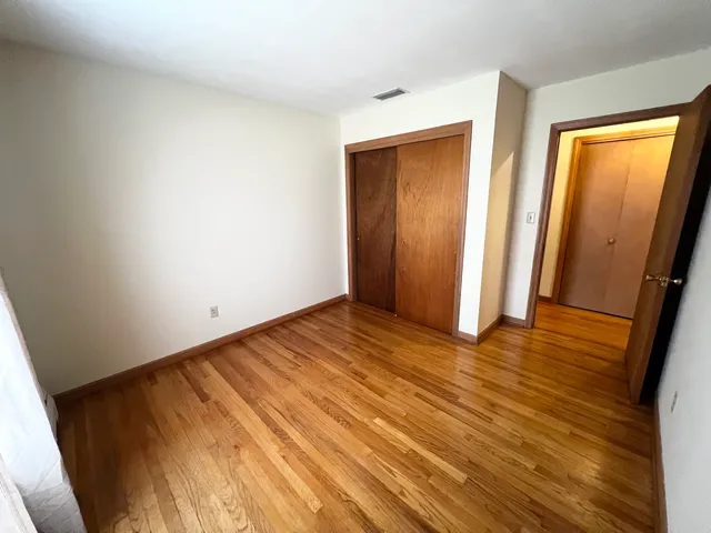 a view of a kitchen with wooden floor and a refrigerator