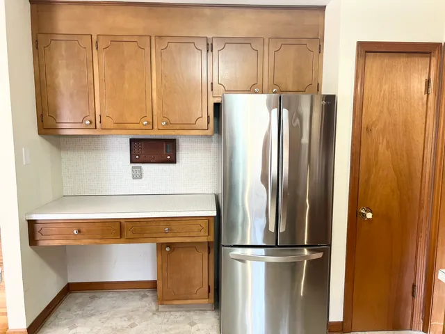 a kitchen with stainless steel appliances granite countertop a refrigerator and a stove top oven