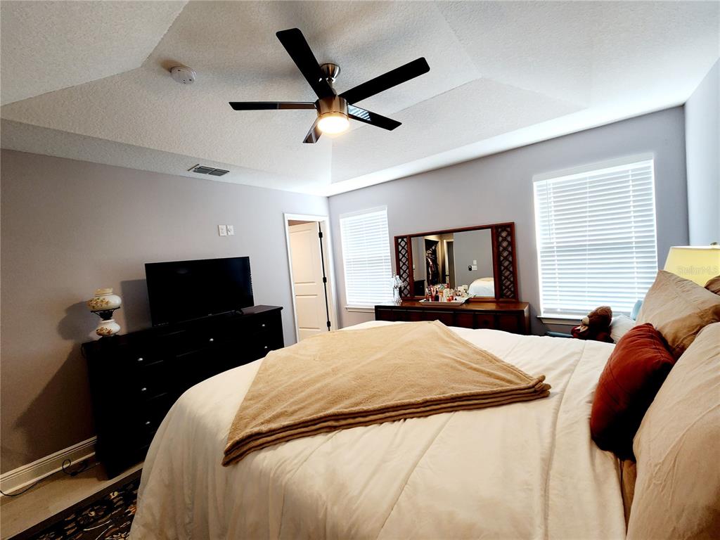 5508 Viola Lee Way Lutz, FL 33558 - Photo 19 of 60 a bedroom with a bed and a chandelier