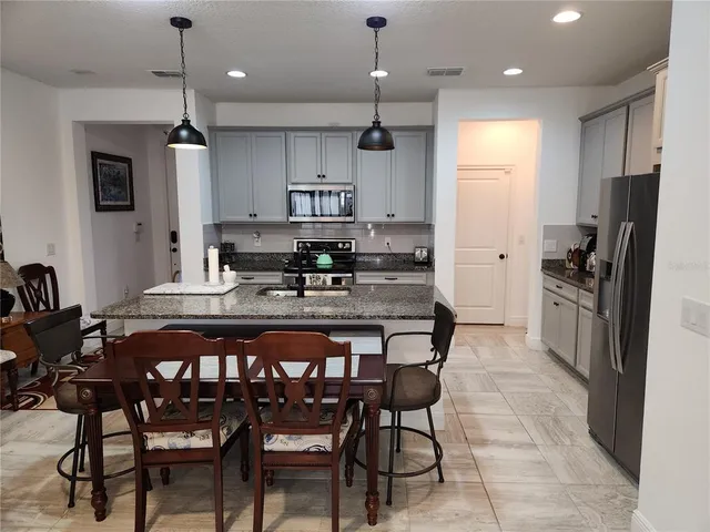a kitchen with center island table and chairs