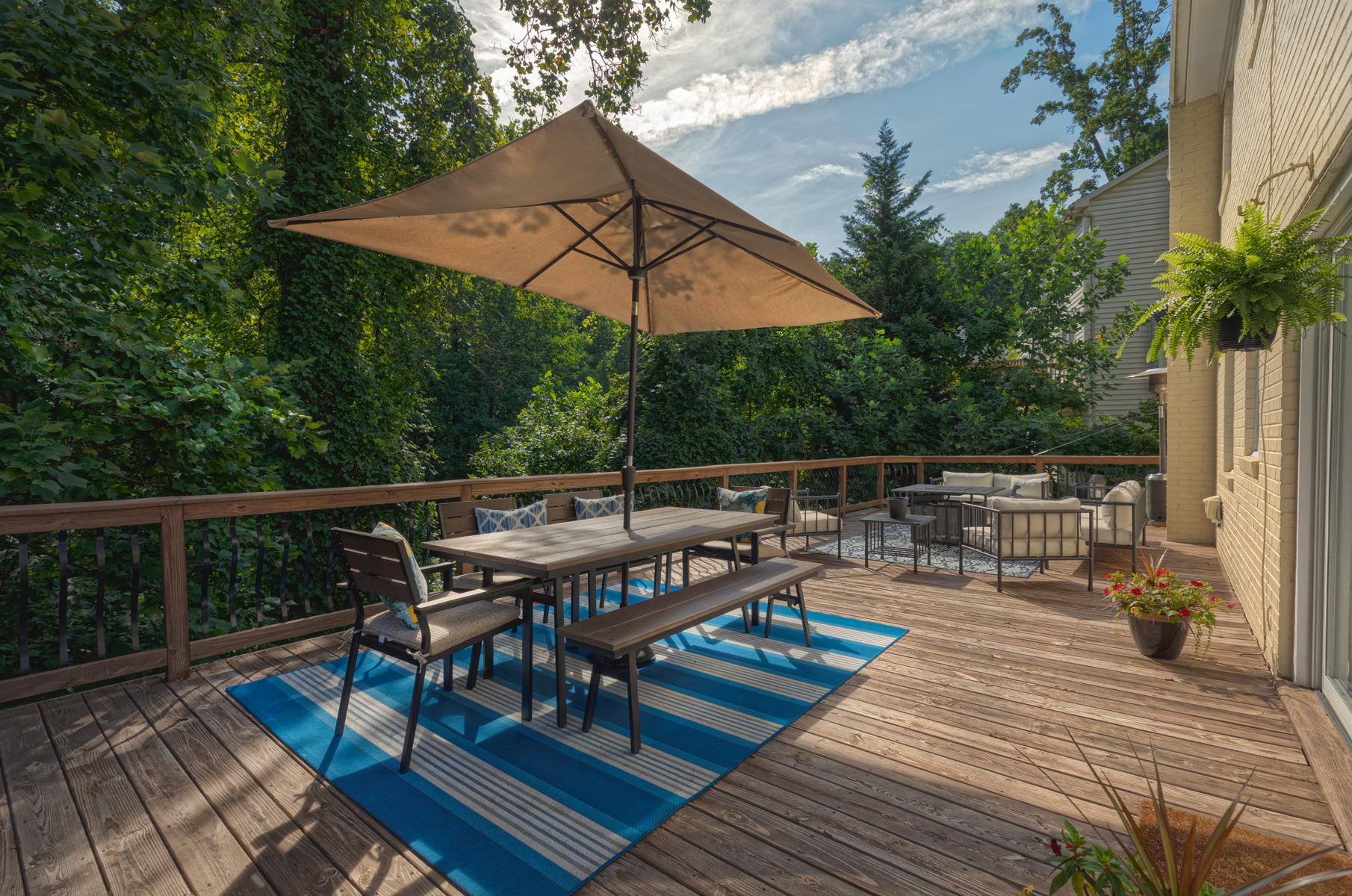 201 Parkcrest Road Southwest Roanoke, VA 24014 - Photo 34 of 39 a view of a roof deck with table and chairs under an umbrella with wooden floor and fence
