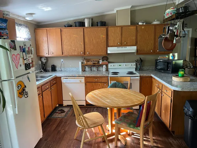 a kitchen with a dining table chairs and refrigerator