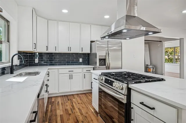 a kitchen with granite countertop a sink stainless steel appliances and cabinets