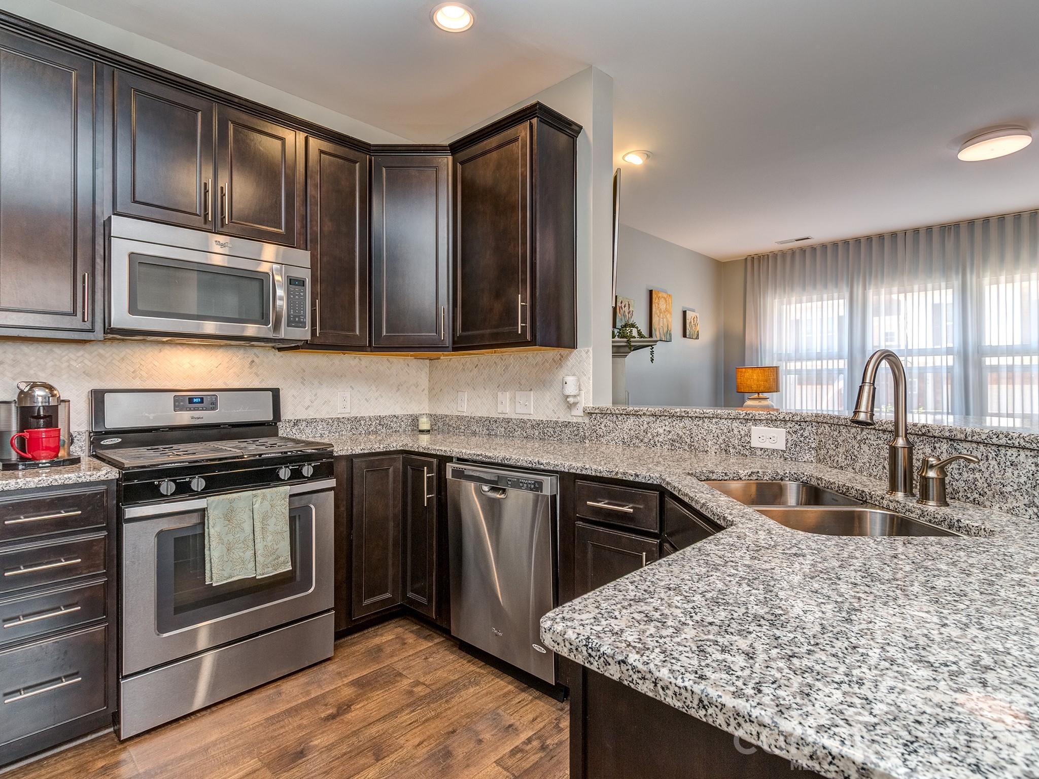 6236 Rockefeller Lane Charlotte, NC 28210 - Photo 6 of 26 a kitchen with stainless steel appliances granite countertop a sink stove and refrigerator