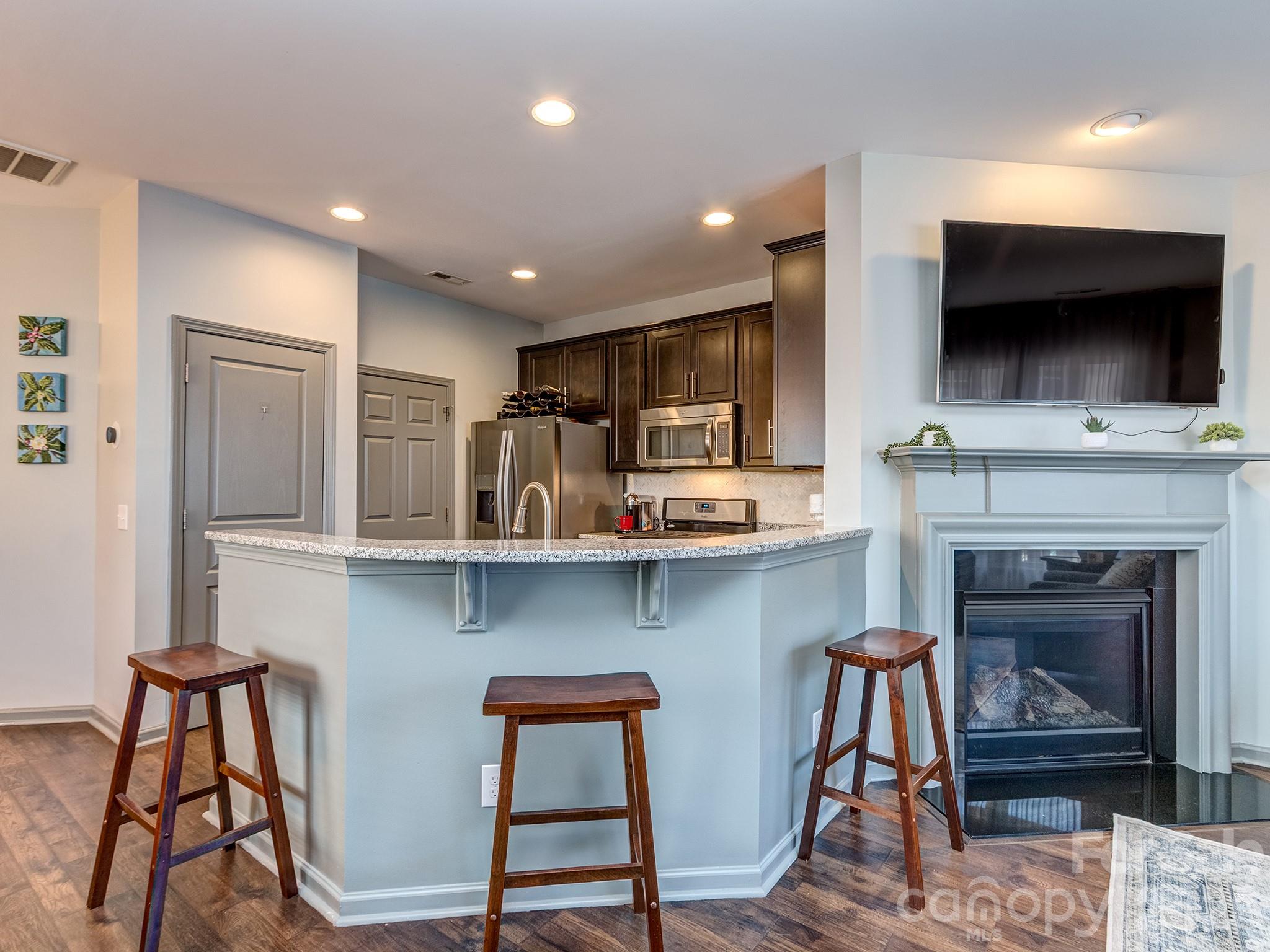 6236 Rockefeller Lane Charlotte, NC 28210 - Photo 9 of 26 a living room with furniture a flat screen tv and kitchen view