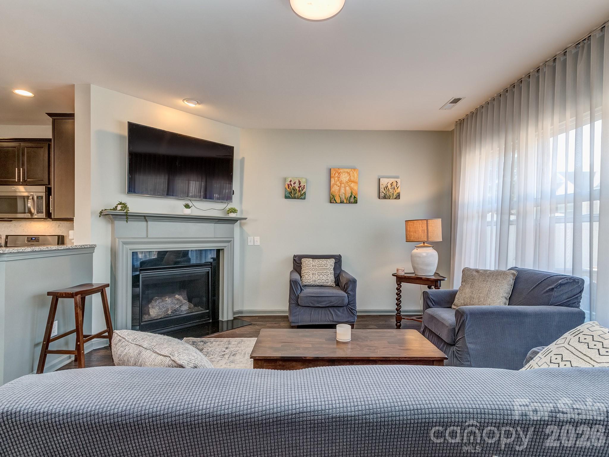 6236 Rockefeller Lane Charlotte, NC 28210 - Photo 10 of 26 a living room with furniture a flat screen tv and a fireplace