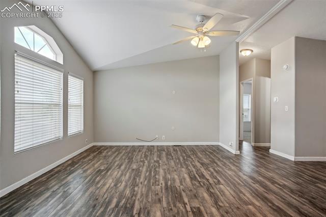 20150 Enoch Road Colorado Springs, CO 80928 - Photo 10 of 50 Spare room with lofted ceiling, dark wood-type flooring, a ceiling fan, and baseboards