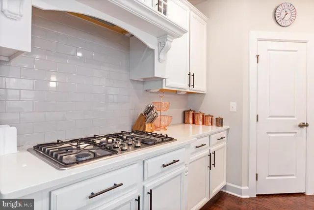 a kitchen with white cabinets and appliances