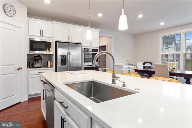a kitchen with stainless steel appliances granite countertop a sink and a refrigerator
