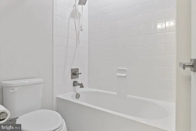 a bath room with a toilet and a bath tub