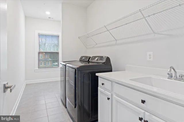 a utility room with sink dryer and washer