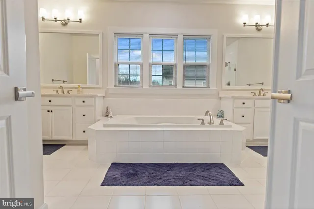 a bathroom with a tub sink and mirror