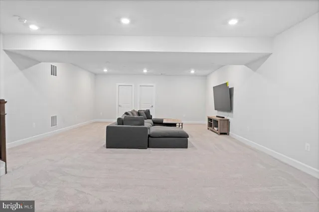 a living room with furniture a flat screen tv and a couch