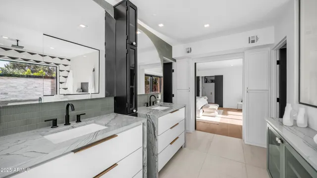 a large white kitchen with a large window and stainless steel appliances