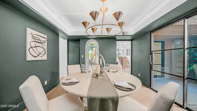 a view of a dining room with furniture and a chandelier fan