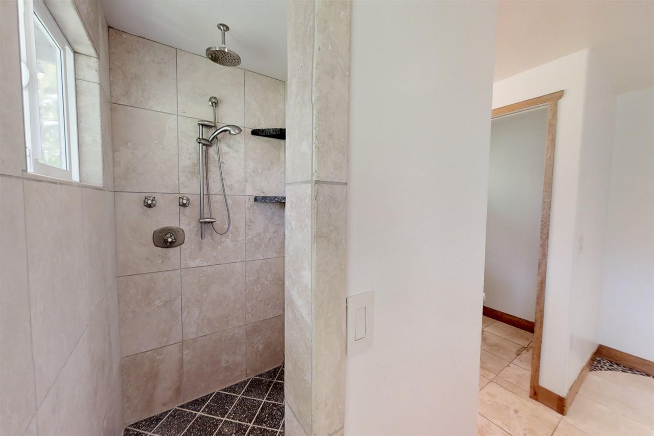 911 Kauhikoa Road Haiku, HI 96708 - Photo 17 of 30 a bathroom with a glass shower door