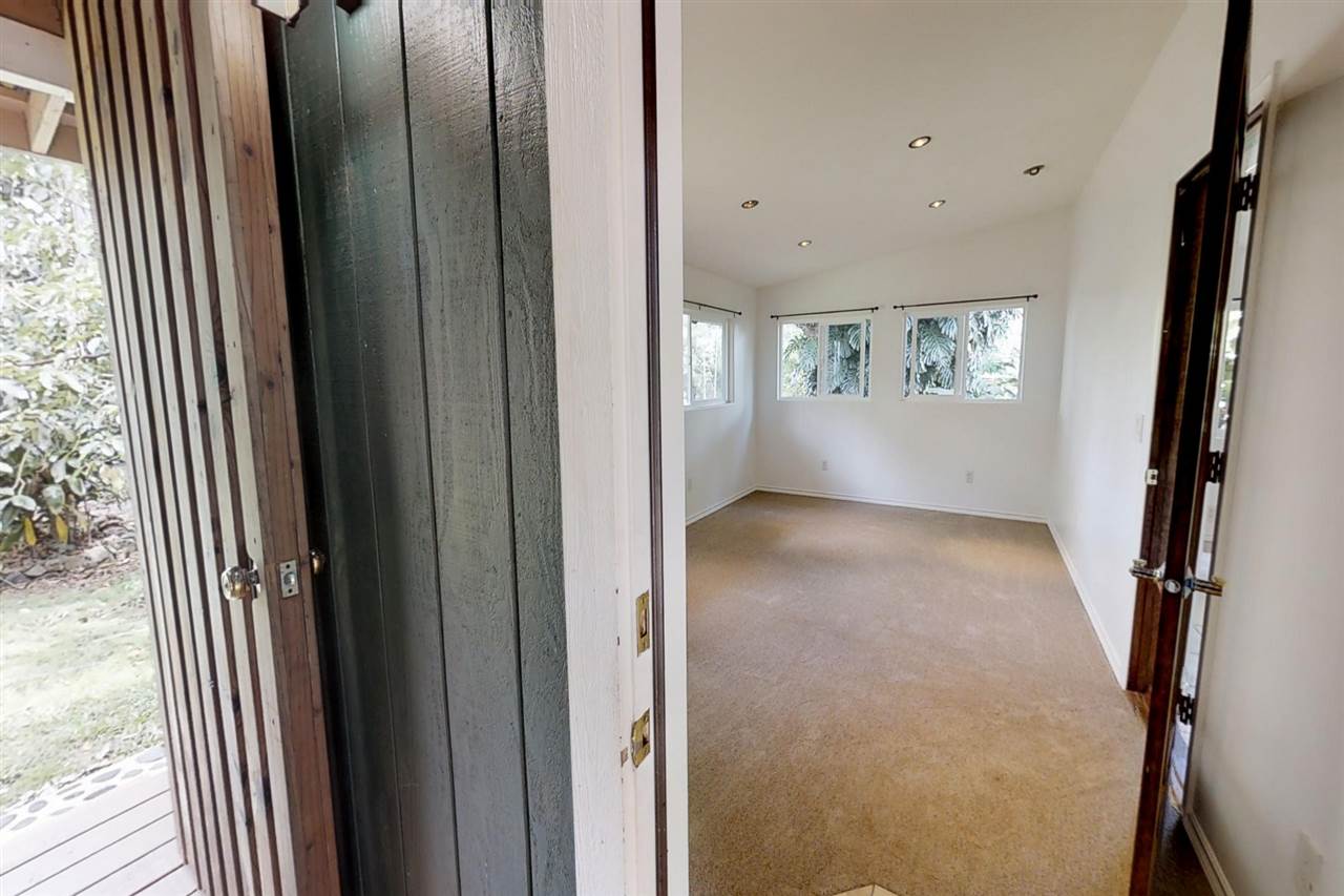 911 Kauhikoa Road Haiku, HI 96708 - Photo 20 of 30 a view of an empty room with wooden floor and a window