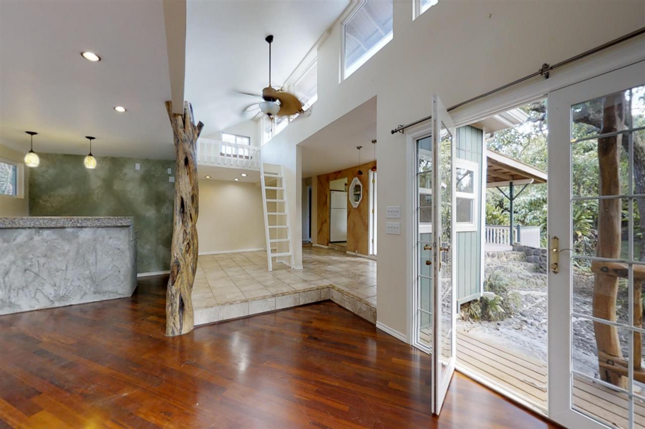 911 Kauhikoa Road Haiku, HI 96708 - Photo 5 of 30 a view of a hallway with wooden floor and a glass door