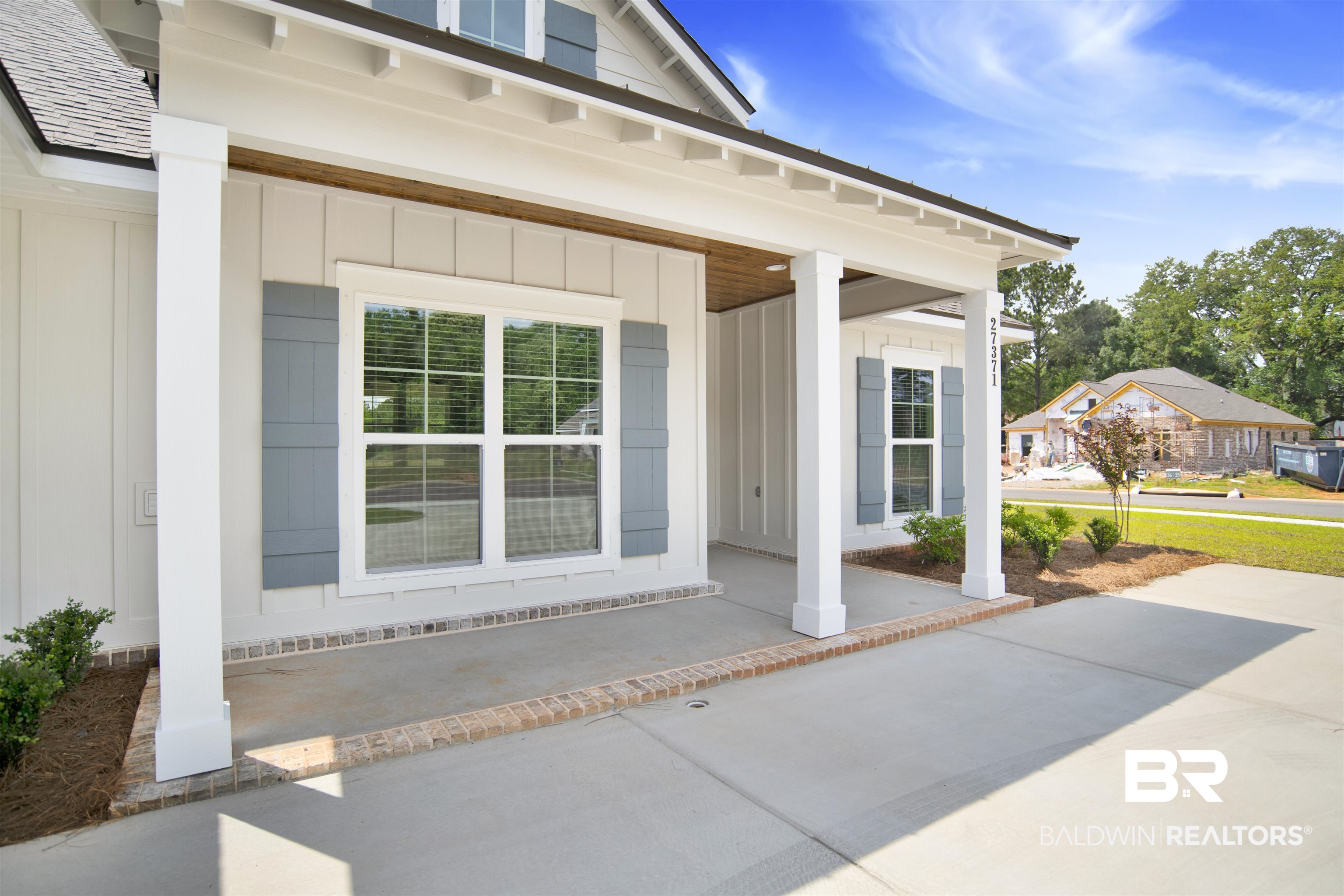 27371 Patch Pl Loop Daphne, AL 36526 - Photo 15 of 63 White board and batten exterior with a covered porch, featuring gray decorative shutters