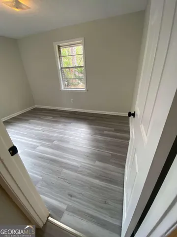 a view of empty room with window and wooden floor