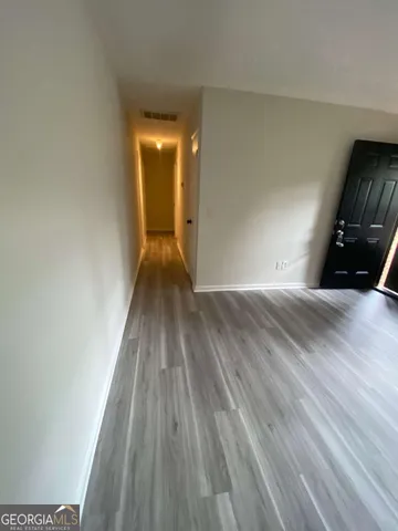 a view of empty room with wooden floor