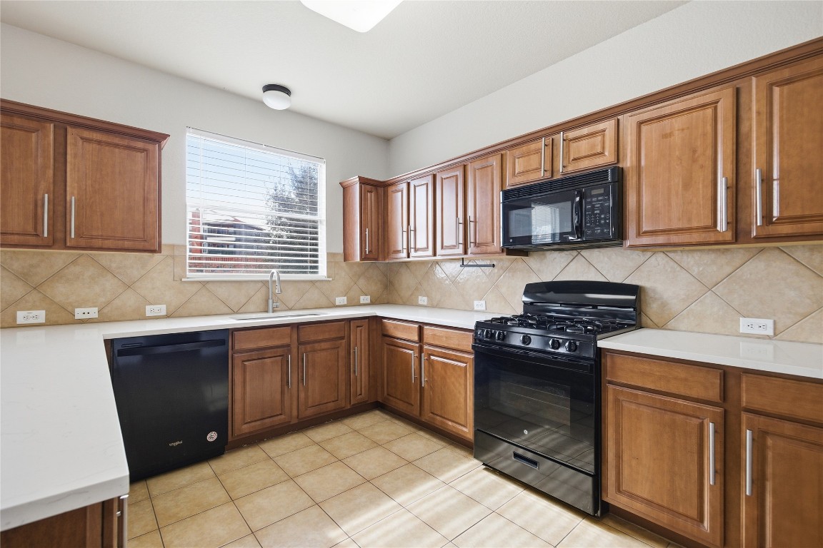 4410 Meadowside Lane Round Rock, TX 78665 - Photo 11 of 22 a kitchen with stainless steel appliances granite countertop a stove sink microwave and window