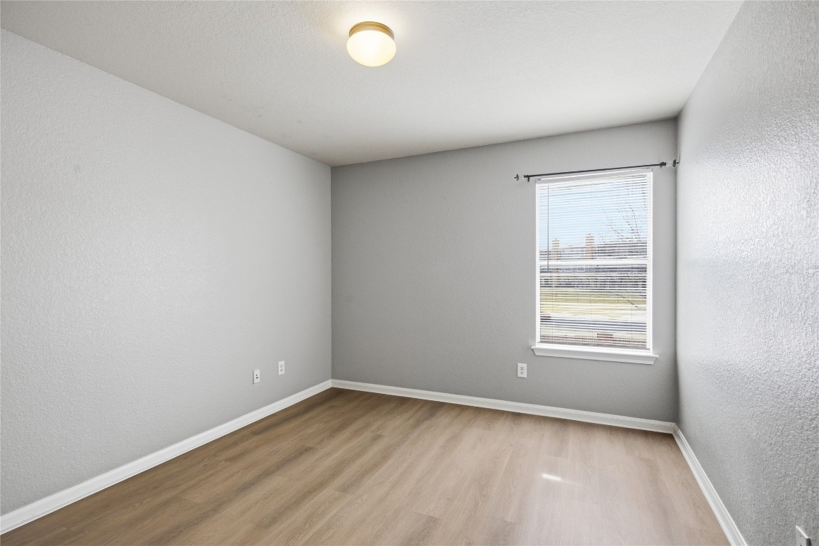 4410 Meadowside Lane Round Rock, TX 78665 - Photo 14 of 22 an empty room with wooden floor and windows