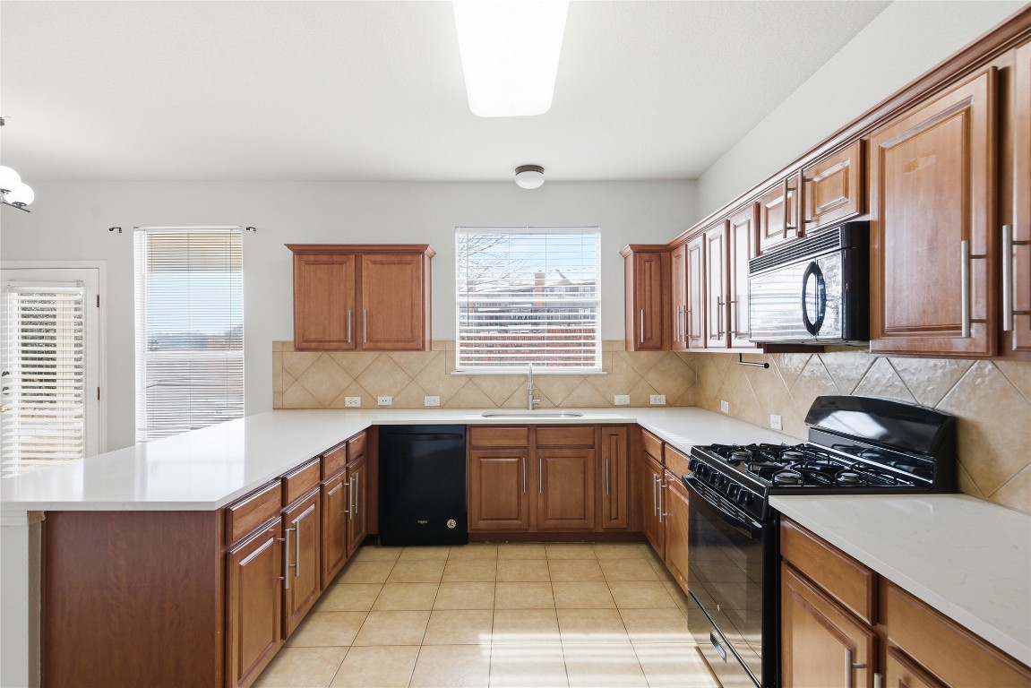 4410 Meadowside Lane Round Rock, TX 78665 - Photo 9 of 22 a kitchen with stainless steel appliances a sink stove and cabinets