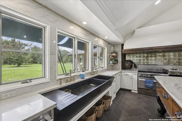 a kitchen with a stove a sink and a granite counter top
