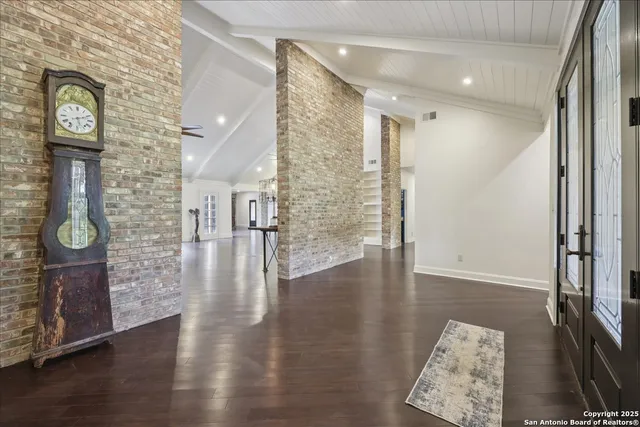 a hallway with hardwood floor and front door