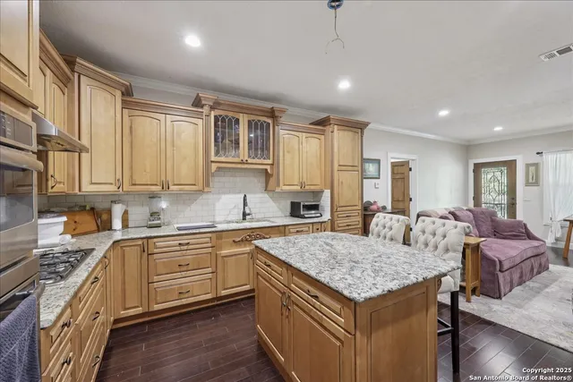 a kitchen that has a lot of cabinets and wooden floor