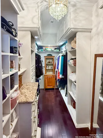 a view of walk in closet with clothes and shoes