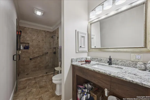 a bathroom with a granite countertop toilet a sink and a mirror