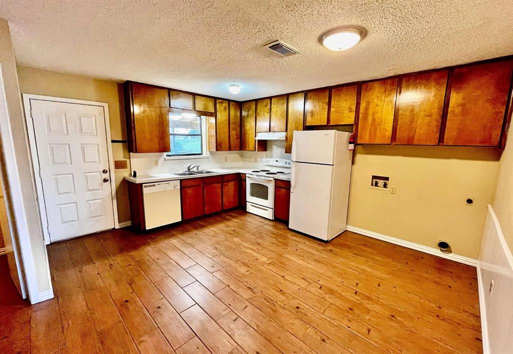 400 Amber Lane, Unit 3 Crowley, TX 76036 - Photo 10 of 16 a large kitchen with wooden floor and stainless steel appliances