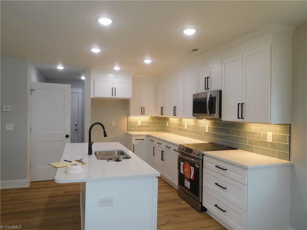 4210 Country Club Road Winston-Salem, NC 27104 - Photo 6 of 41 KITCHEN COMPLETE WITH QUARTZ COUNTERS, TILE BACKSPLASH, UNDER CABINET LIGHTS, SS APLIANCES & ISLAND W/SEATING.
