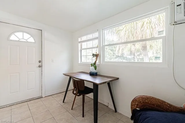 a dining room with furniture and a floor to ceiling window