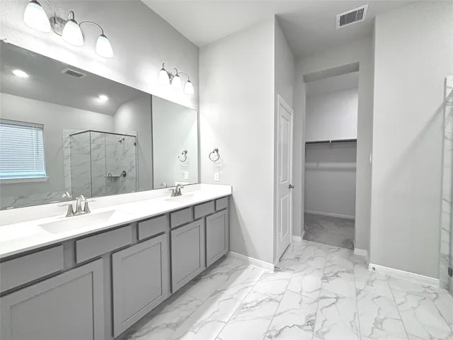 a spacious bathroom with a mirror sink and shower